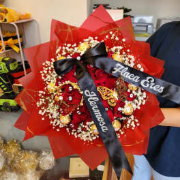 Red rose bouquet with baby’s breath, gold chocolates, and black ribbons