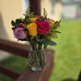 Bouquet of multicolored roses in a clear glass vase