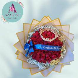 Round bouquet of red roses with a blue ribbon and gold crown topper