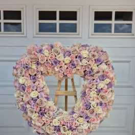 Heart-shaped rose arrangement on an easel in pastel pink, lavender, and cream