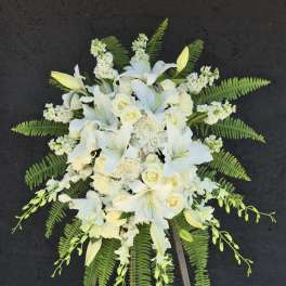 White floral standing spray on a wooden easel