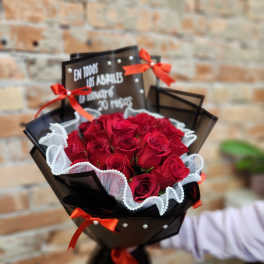 Bouquet of red roses wrapped in black paper with red ribbons