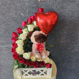 Heart-shaped rose arrangement with a plush dog and red balloon in a white box