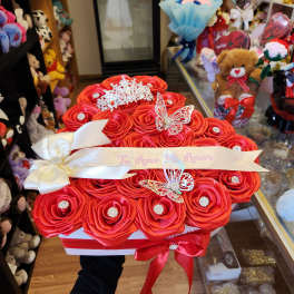 Red rose bouquet in a white box with ribbon and butterfly decorations