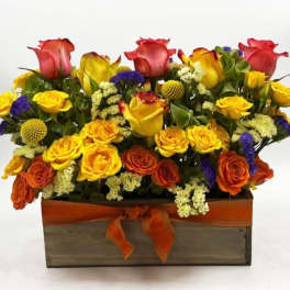 Mixed roses in yellow, pink, orange, and red arranged in a wooden box