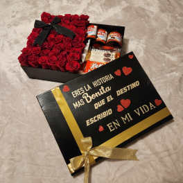 Box of red roses with chocolates and a black gift lid with gold lettering