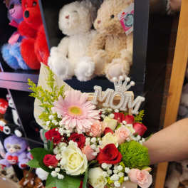 Bouquet of roses and a pink gerbera daisy in a gift box with a "Mom" topper