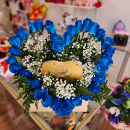 Blue roses arranged around a gold Lindor chocolate box