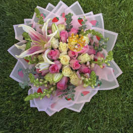 Pink and cream rose bouquet with lilies in strawberry-patterned wrap