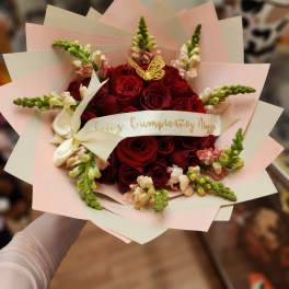 Bouquet of red roses with pink snapdragons and a cream ribbon