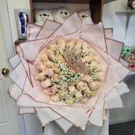 Bouquet of pale pink roses with pearl accents and decorative crowns