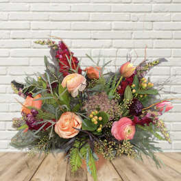 Mixed bouquet of peach and pink flowers in a vase