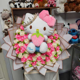 Hello Kitty plush surrounded by pink and white roses