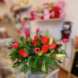 Bouquet of red roses and pink tulips in a glass vase