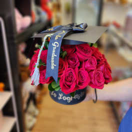Bouquet of hot pink roses in a black hat box with a graduation ribbon