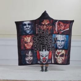 Person holding a horror-themed blanket with multiple masked faces