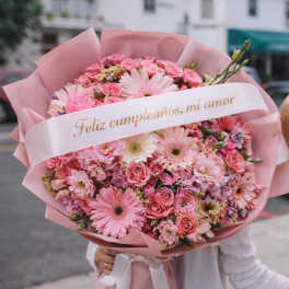 Pink mixed flower bouquet wrapped in pink paper with a birthday ribbon