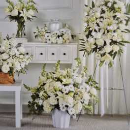 White floral arrangements in vases and a standing spray