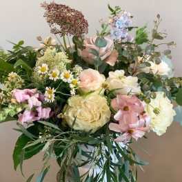 Loose bouquet of pastel roses, daisies, and mixed blooms