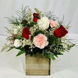 Red and white roses with pink carnations in a wooden box