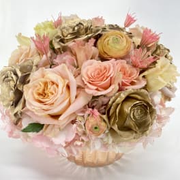 Bouquet of blush and gold roses in a peach vase