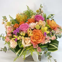 Mixed bouquet of orange and pink roses in a wooden box