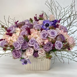 Lavender and blush rose arrangement in a cream vase