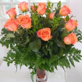 Peach roses arranged in a clear glass vase