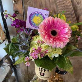 Mug of mixed flowers with pink gerbera daisy, hydrangea, and a coffee shop gift card tucked inside.