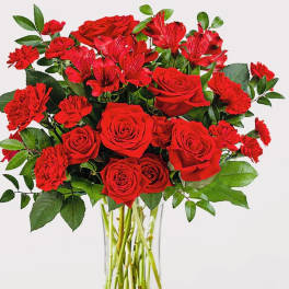 Red roses and carnations in a clear glass vase