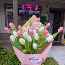 Pink and white tulip bouquet in pink wrapping with a Mother's Day topper