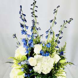 Blue and white floral arrangement in a clear glass vase