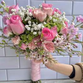 Hand-tied bouquet of pink roses and white baby's breath