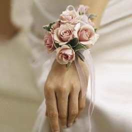 Pink rose wrist corsage with ribbon on a hand