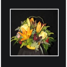 Yellow and orange floral arrangement in a yellow container
