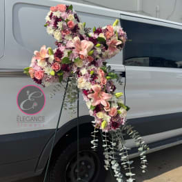 Large pink and white floral cross on a stand