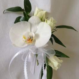 White orchid bouquet with ribbon and dark green leaves