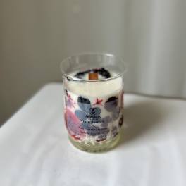 Scented candle in a clear glass jar with a printed label