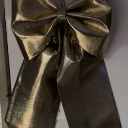 Large metallic gold bow on a white surface