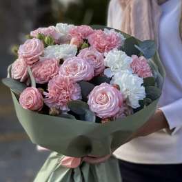 Bouquet of pink roses and white carnations wrapped in green paper