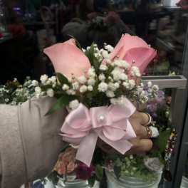 Pink rose boutonniere with baby's breath and a satin bow