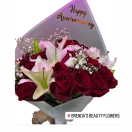 Bouquet of red roses and white lilies with an anniversary card