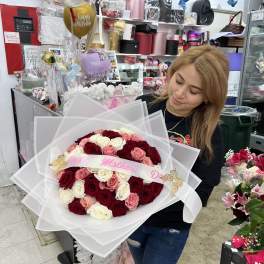 Large bouquet of red, pink, and white roses wrapped in white paper