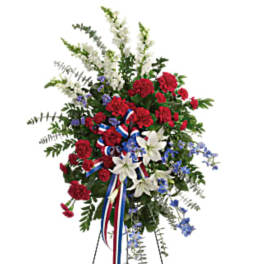 Standing floral spray with red, white, and blue flowers on an easel