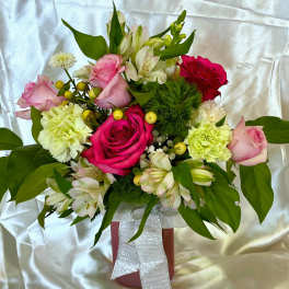 Bouquet of pink and red roses with white flowers in a pink vase