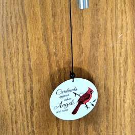 Cardinal-themed metal wind chime hanging on a wooden door