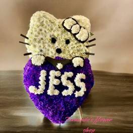 Standing white and purple floral arrangement shaped like a cartoon cat with the name Jess