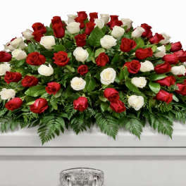 Red and white roses arranged on a white casket