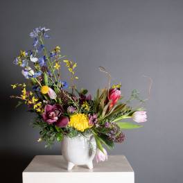 Colorful mixed flower arrangement in a white ceramic vase