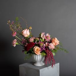 Mixed pink and peach flower arrangement in a white vase